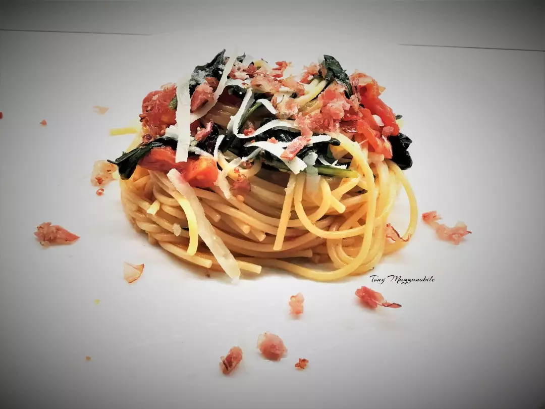Spaghetti con catalogna, pomodori mini plum e briciole di speck croccanti